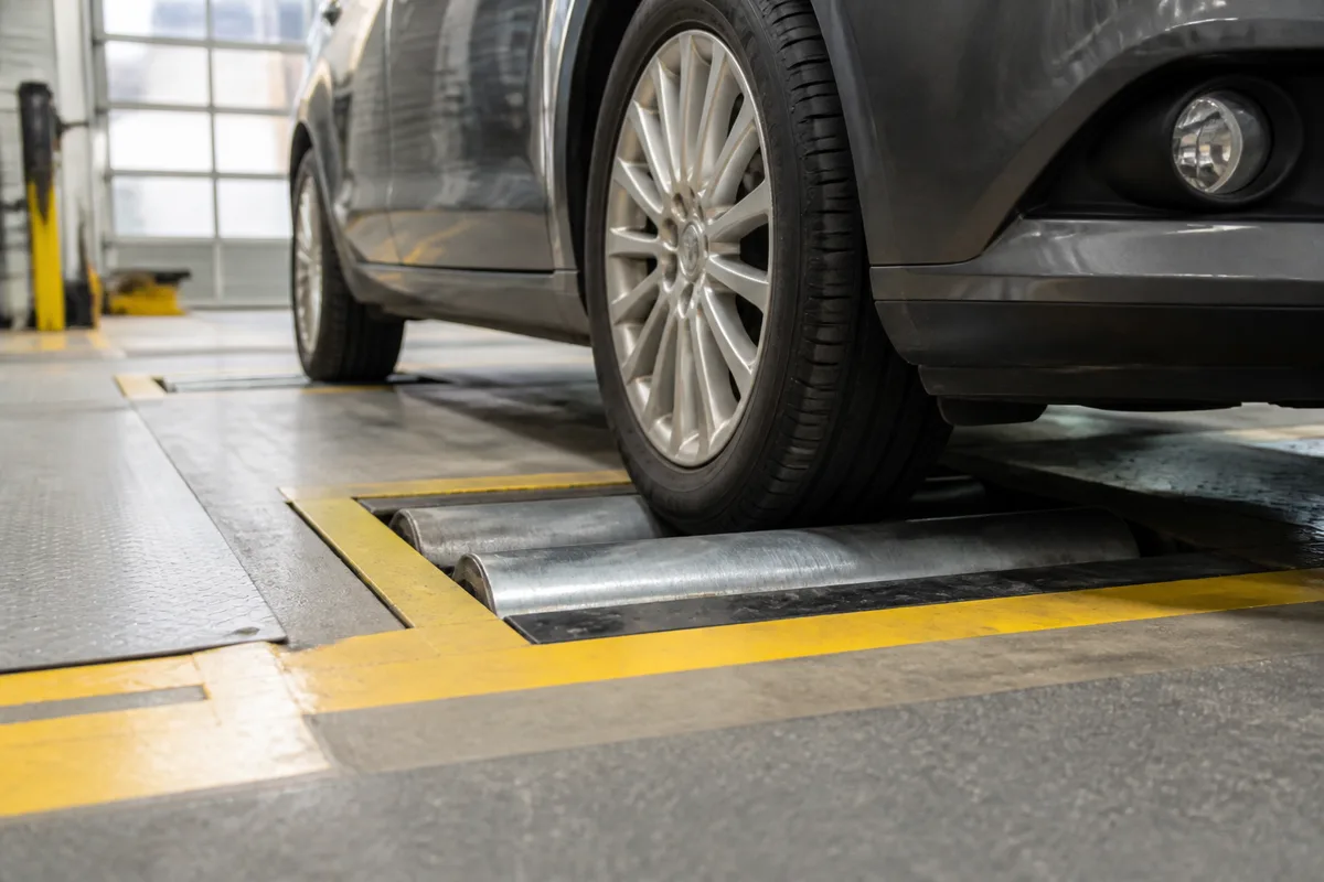 Voiture positionnée sur un pont élévateur dans un centre de contrôle technique